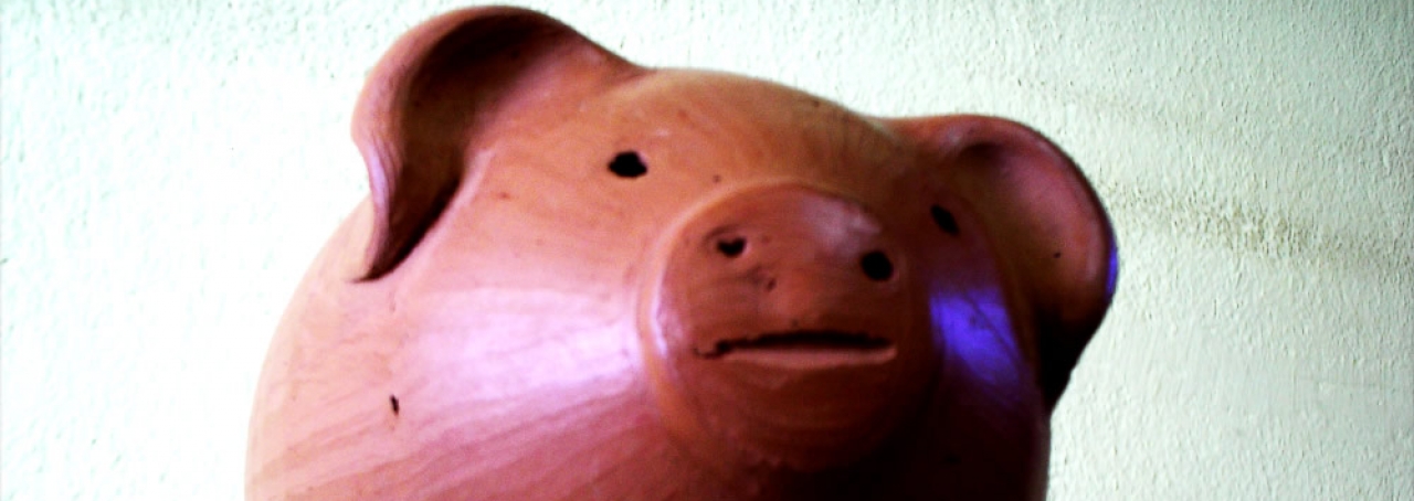 Cofrinho de porco em mesa de vidro