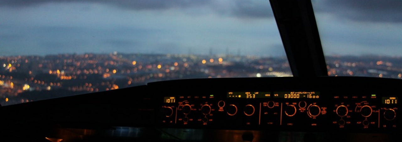 Cidade ao fundo. Janela de avião. Painel de instrumentos de avião