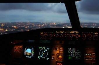 Cidade ao fundo. Janela de avião. Painel de instrumentos de avião